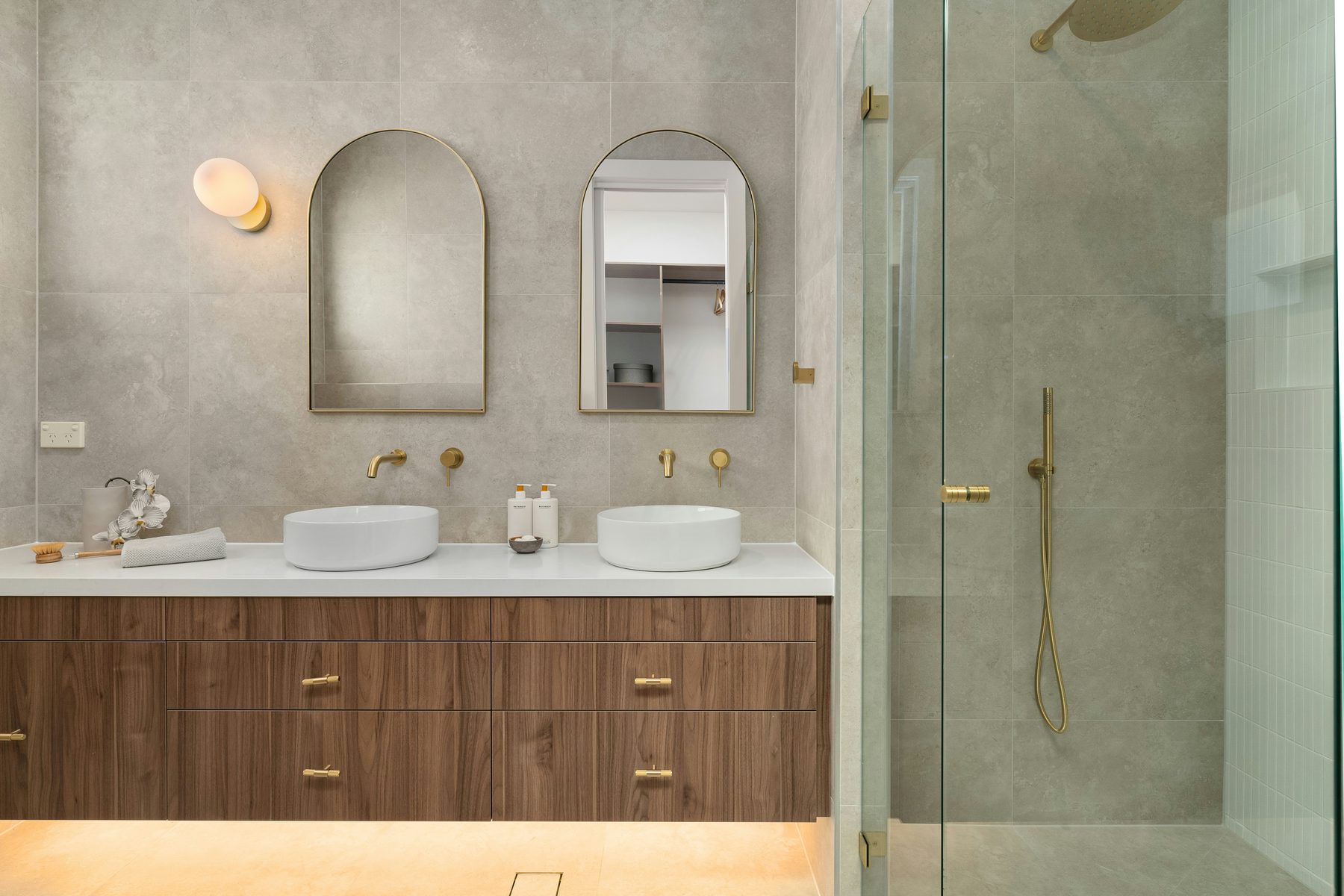 Twin basins on a walnut vanity with brass fittings